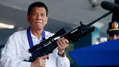 Rodrigo Duterte jokes to photographers as he holds a rifle in 2018. Photo / AP