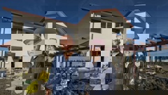 The Zhangs at their two-storey property on Scissons Rd, Pākōwhai, where floodwaters from Cyclone Gabrielle reached the roof. Their dog, Huahua, was lost in the flooding. Photo / Paul Taylor