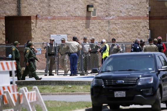 Law enforcement, and other first responders, gather outside Robb Elementary School following a shooting, May 24, 2022, in Uvalde, Texas. A criminal investigation in Texas over the hesitant police response to the Robb Elementary School shooting remains ongoing a year after a gunman killed 19 children and two teachers in Uvalde. (AP Photo/Dario Lopez-Mills, File)