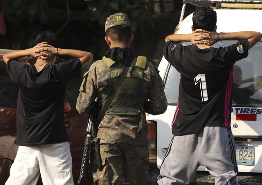 A soldier checks the identification of youths on the main street of La Campanera neighborhood in Soyapango, El Salvador. Photo / AP