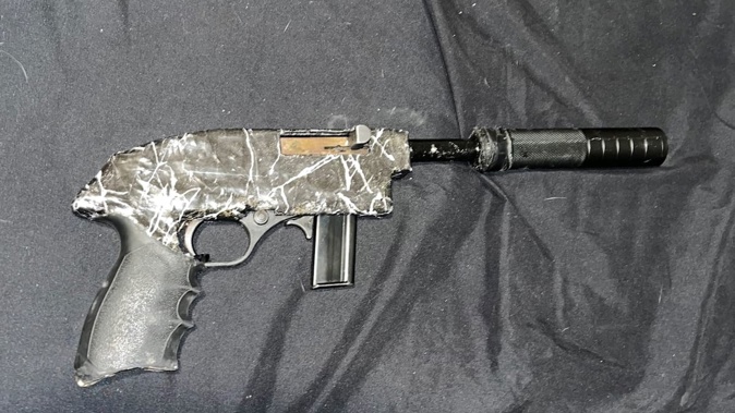 Police have seized a stash of guns, ammunition, cash and illicit drugs in raid in Central Auckland this morning, with two people facing charges. Photo / NZ Police