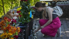 A woman lights a candle at a shopping center, after a rocket attack in Kremenchuk, Ukraine, Tuesday, June 28, 2022. (Photo / AP)