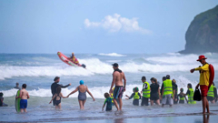 Swimmers at Piha Beach under the watchful eye of lifeguards, a day after two people died in an unpatrolled section of the beach. Photo / Alex Burton