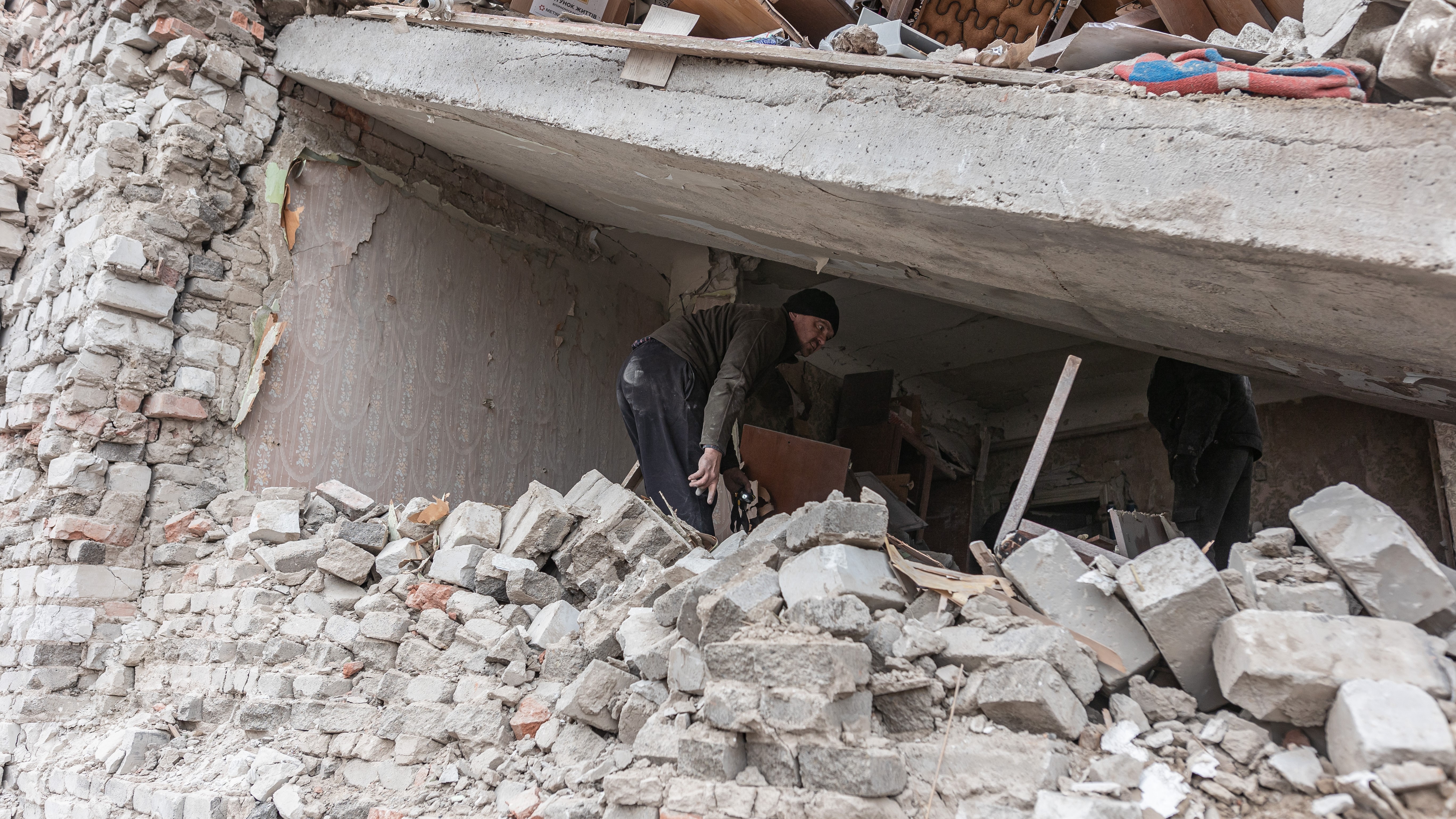 A man searches through rubble in a collapsed section of a building in Kostiantynivka, Ukraine, following a Russian attack on November 21, 2024. (Photo by Diego Herrera Carcedo/Anadolu via Getty Images)