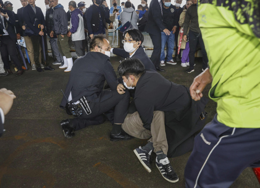 A man, on the ground, who threw what appeared to be a smoke bomb, is caught at a port in Wakayama, western Japan Saturday, April 15, 2023. Japan’s NHK television reported Saturday that a loud explosion occurred at the western Japanese port during Prime Minister Fumio Kishida’s visit, but there were no injuries. Photo / AP
