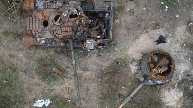 A man passes by Russian tanks destroyed in a recent battle against Ukrainians in the village of Dmytrivka. Photo / AP