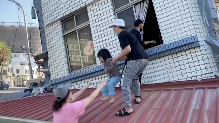 Residents rescue a child from a partially collapsed building in Hualien. Photo / AP