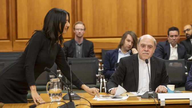 Green MP Golriz Ghahraman handing photographs of people killed in protests in Iran to Iranian ambassador Reza Nazar Ahari during his appearance before the Foreign Affairs, Defence and Trade select committee. Photo / Mark Mitchell