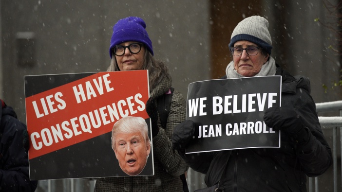 People carry anti-Trump signs outside federal court, in New York, Tuesday, Jan. 16, 2024, the venue for the E. Jean Carroll's case against Donald Trump to determine how much more he owes the writer for denying that he sexually assaulted her in the 1990s and accusing her of lying about her claims. Photo / AP