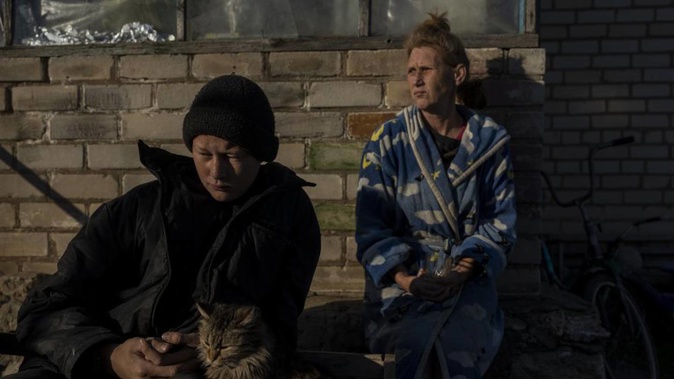 Vitaliy Mysharskiy, 14, left, and his grandmother Tanya Babii sit in the yard of the family house in the recently liberated village of Kyselivka, outskirts of Kherson, southern Ukraine. Photo / AP