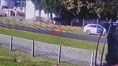 A still taken from a video showing a person taking a baby from the back seat of a stolen car and leaving the child on the grass verge in Waitara.