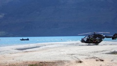 A rescue helicopter sits on a sandbar amid the emergency services response. Photo / Rhyva Van Onselen