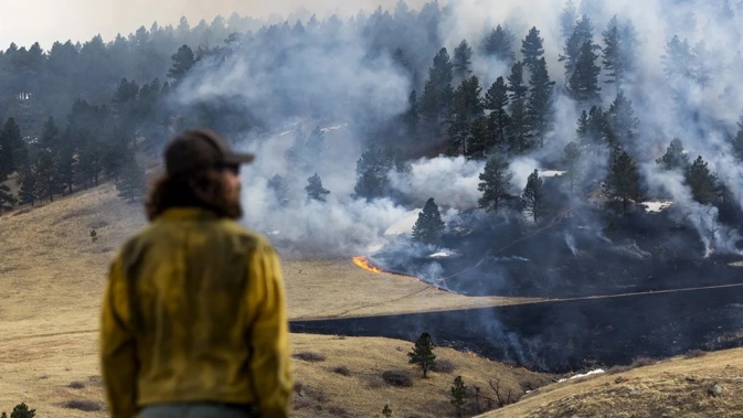 A firefighter watches as a fire burns through grass on March 26, 2022 in Boulder, Colorado. Michael Ciaglo/Getty Images