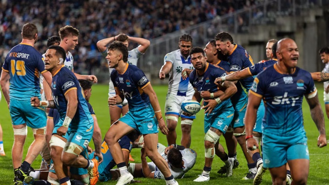 Moana Pasifika players celebrate their win over the Blues. Photo / Photosport