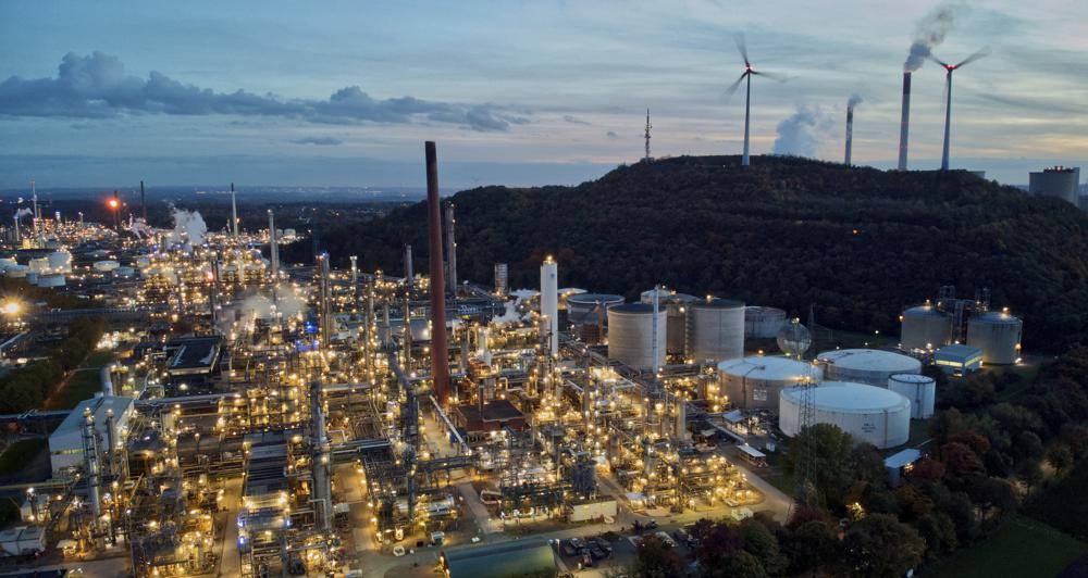 FILE - Wind turbines turn on top of a dump next to the 'BP Refinery Scholven' in Gelsenkirchen, Germany, Oct. 22, 2022. Spiraling energy costs caused by various economic factors and the Ukraine war could be a turning point toward cleaner energy, the International Energy Agency said in a report Thursday, Oct. 27. It found the global demand for fossil fuels, including coal, oil, and natural gas, is set to peak or plateau in the next few decades. (AP Photo/Michael Sohn, File)