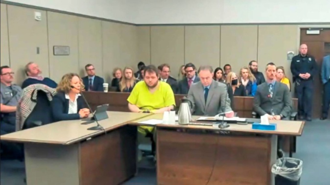 In this image taken from El Paso County District Court video, Anderson Lee Aldrich, 22, centre, sits during a court appearance in Colorado Springs, Colorado, on Tuesday. 2022. Aldrich, the suspect accused of entering a Colorado gay nightclub clad in body armour and opening fire with an AR-15-style rifle, killing five people and wounding 17 others, was charged by prosecutors on Tuesday with 305 criminal counts including hate crimes and murder. Photo / via AP