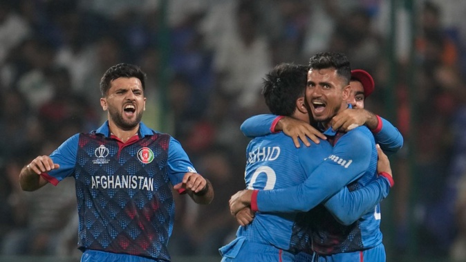 Afghanistan's Rashid Khan is hugged by team members as they celebrate the wicket of England's Adil Rashid during their Cricket World Cup clash. Photo / AP