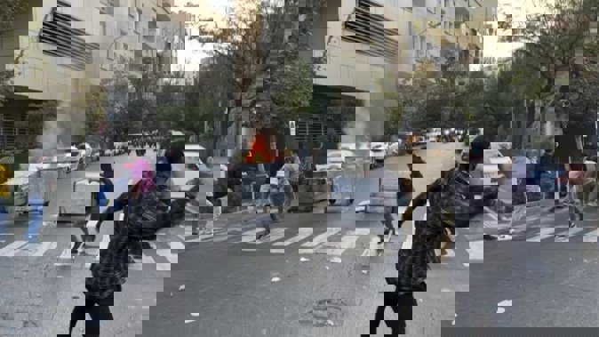 Protesters throw stones at anti-riot police during a protest over the death of a young woman who had been detained for violating the country's conservative dress code. Photo / AP