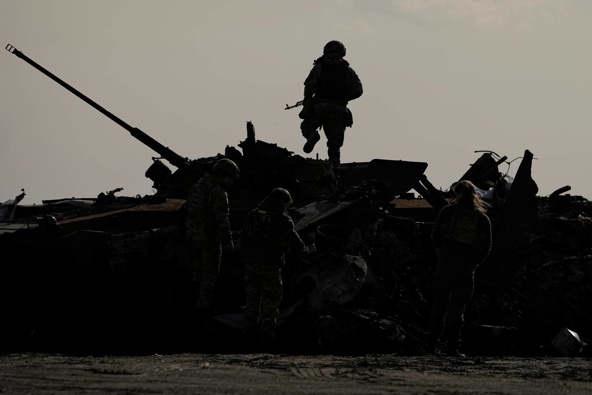 A Ukrainian serviceman walks on a destroyed Russian fighting vehicle in Bucha, Ukraine. Photo / AP