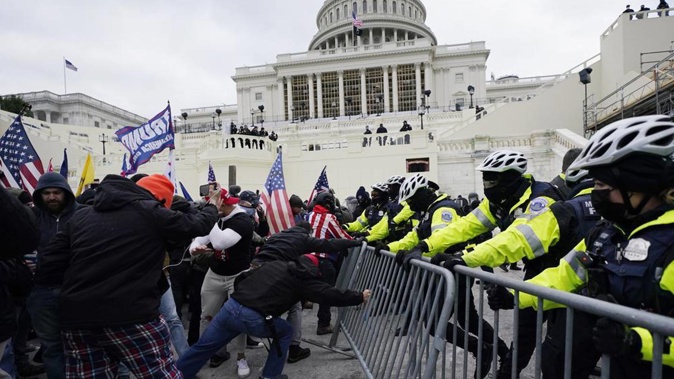 Insurrectionists loyal to President Donald Trump try to break through a police barrier on January 6 last year. Photo / AP