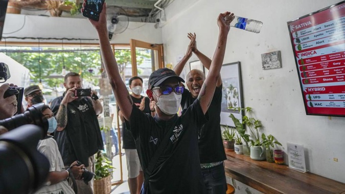 The first customer of the day, Rittipomng Bachkul celebrates after buying legal marijuana at the Highland Cafe in Bangkok. (Photo / AP)