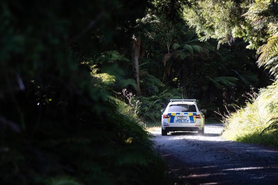 Fire investigators and police at the scene of the house-bus fire on Blue Spur Rd, Hokitika. Photo / George Heard