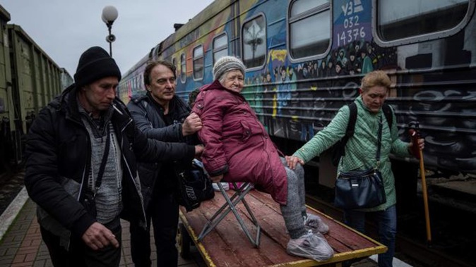 Relatives of a 94-year-old woman, Elizaveta, transport her by a cargo cart to an evacuation train in Kherson, Ukraine on Thursday after renewed Russian shelling. Photo / AP