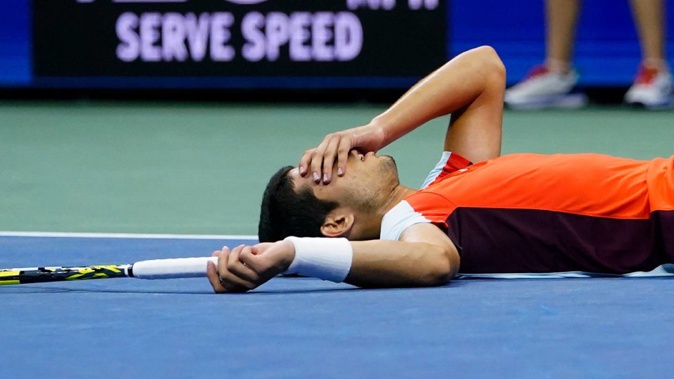 Carlos Alcaraz collapses after taking out match point against Jannik Sinner. Photo / AP