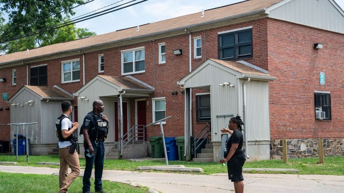 Resident Ashley Johnson speaks with Baltimore Police officers about the mass shooting incident in the Southern District of Baltimore. Photo / AP