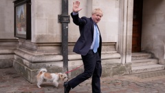 Britain's Prime Minister Boris Johnson waves at the media as he leaves with his dog Dilyn after voting at a polling station in London, for local council elections, Thursday, May 5, 2022. (Photo / AP)