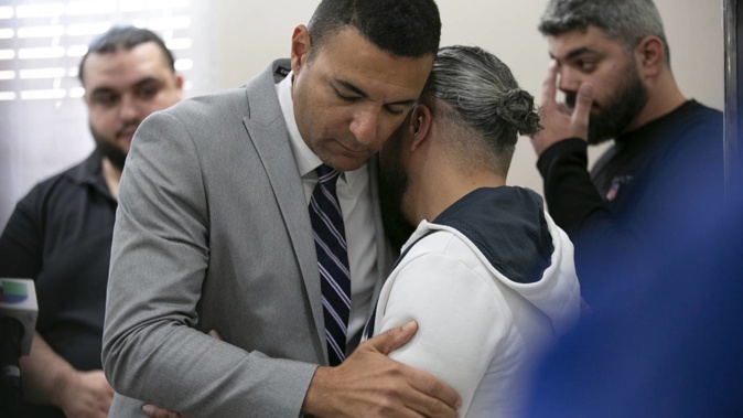 Ahmed Rehab, left, executive director of the Chicago chapter of the Council on American-Islamic Relations, embraces Odey Al-Fayoume, father of Wadea Al-Fayoume, 6. Photo / AP