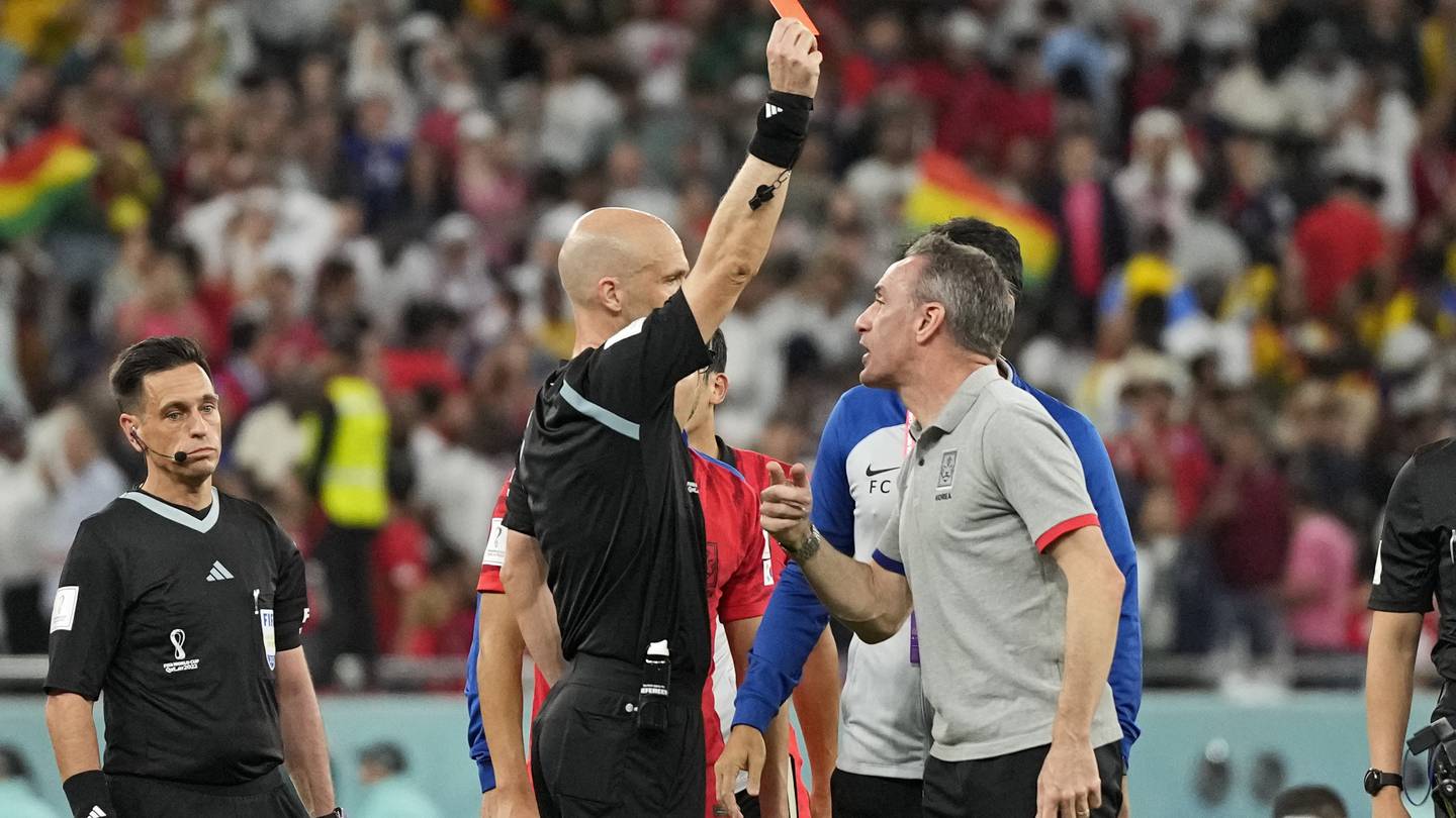 Referee Anthony Taylor shows the red card to South Korea's head coach Paulo Bento. Photo / AP