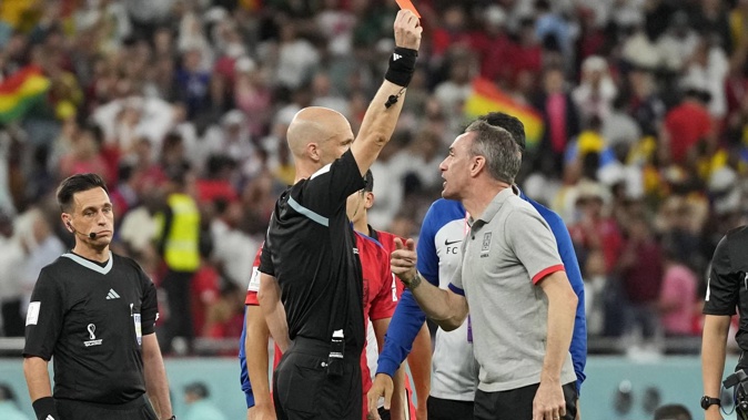 Referee Anthony Taylor shows the red card to South Korea's head coach Paulo Bento. Photo / AP