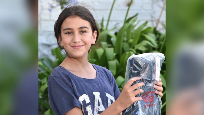 St Hilda's Collegiate School pupil Jahdae Ainsley holds up her newly bought school uniform in Dunedin yesterday. (Photo / Christine O'Connor)