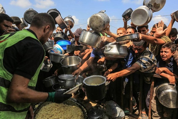 Palestinians, including children, wait in line to receive hot meals distributed by the charity organisation at Al-Mawasi area in Khan Yunis, Gaza. Photo / Getty Images