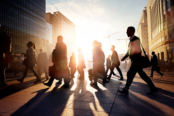 Employees walking to work in the city at sunrise - stock photo