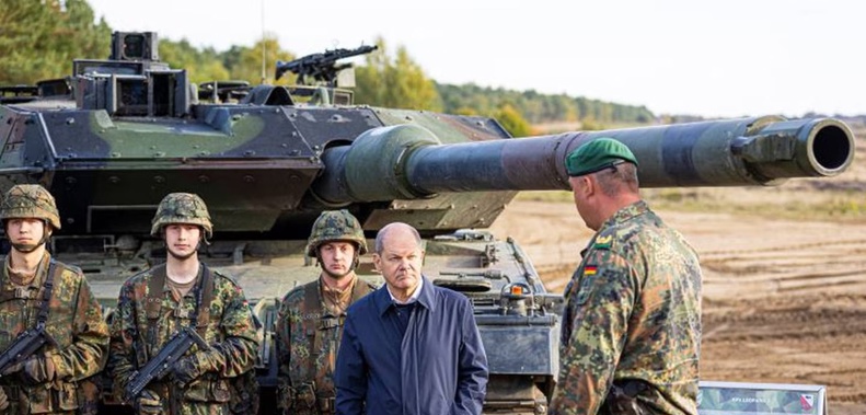 German Chancellor Olaf Scholz talks to German army Bundeswehr soldiers at a "Leopard 2" main battle tank during a training and instruction exercise in Ostenholz, Germany in October last year. Germany has now committed to sending some of the tanks to Ukraine. Photo / AP