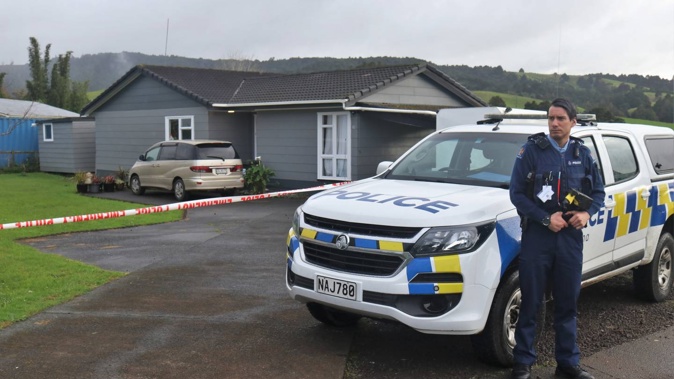 A police officer stands guard at the Taraire St home where a homicide investigation is underway. Photo / Peter de Graaf