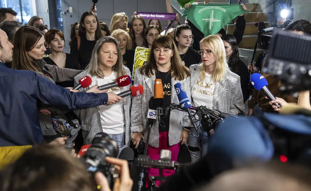Activist, Justyna Wydrzyńska,center, speaks to reporters in Warsaw, Poland, on Tuesday March 14, 2023. A court on Tuesday convicted Wydrzyńska for helping a victim of domestic violence access abortion pills in Poland, and sentenced her to eight months of community service. (AP Photo)