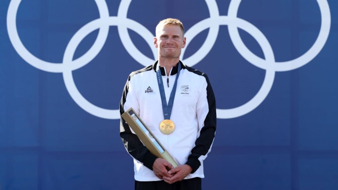 Gold medallist Finn Butcher of Team New Zealand stands on the podium during the Canoe Slalom Men's Kayak Cross medal ceremony at the Paris Olympics 2024. Photo / Getty Images
