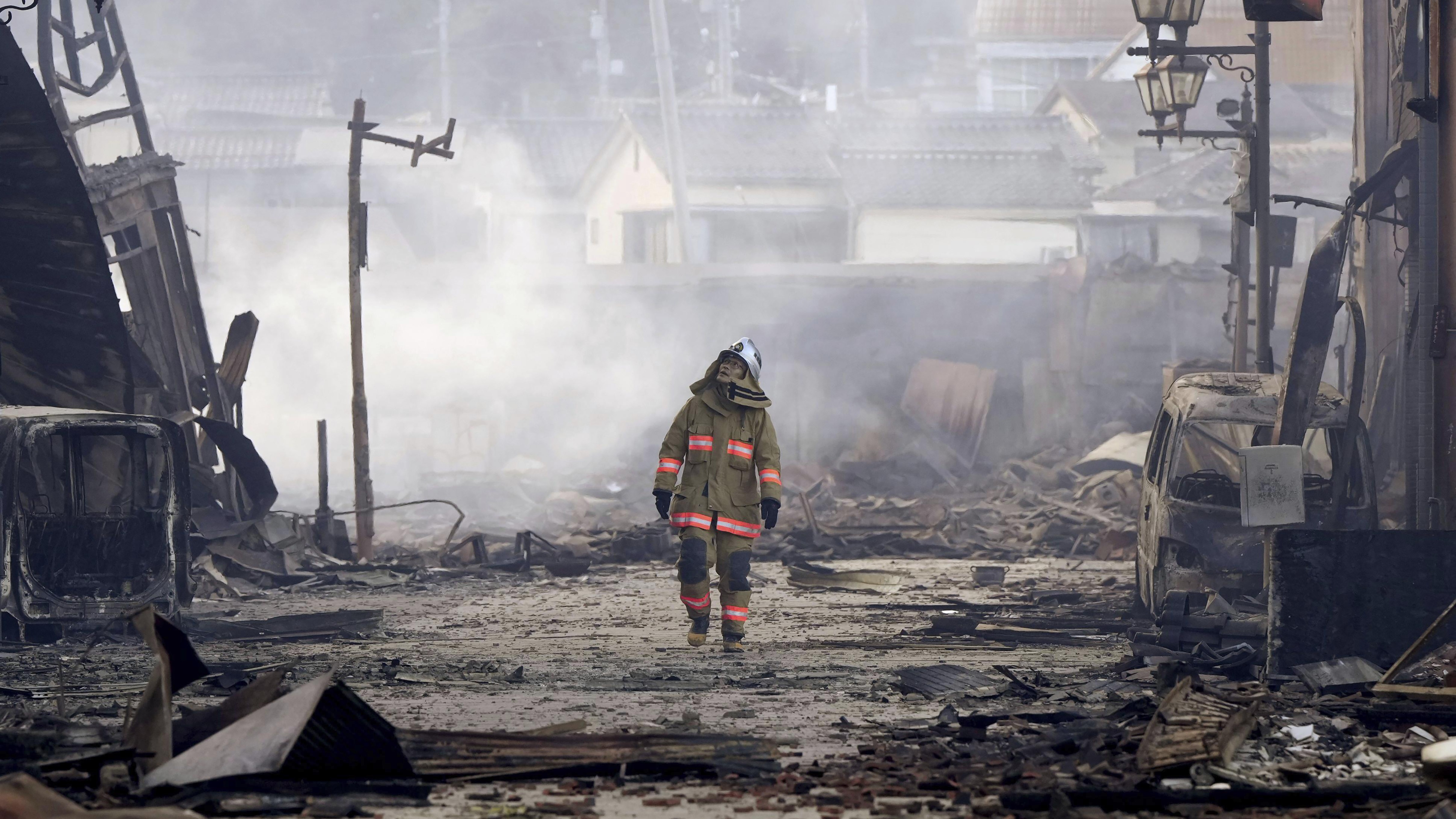 A firefighter walks through the rubble and wreckage of a burnt-out marketplace following earthquake in Wajima, Ishikawa prefecture, Japan. Photo / Kyodo News via AP