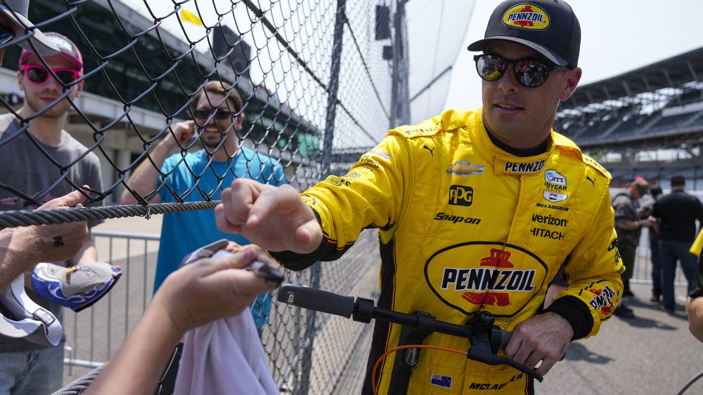 Scott McLaughlin reaches for a pen to sign autographs for fans during practice for the Indianapolis 500. Photo / AP