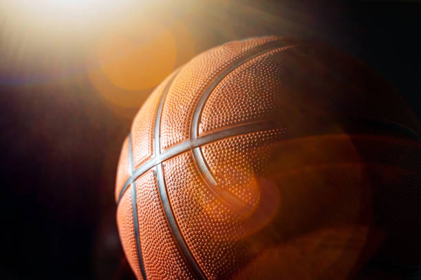 Basketball and Light Flare Against Black Background - stock photo
