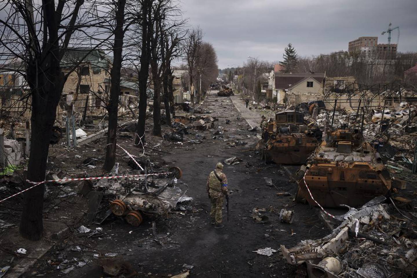 A Ukrainian serviceman walks amid destroyed Russian tanks in Bucha, on the outskirts of Kyiv, Ukraine. (Photo / AP)