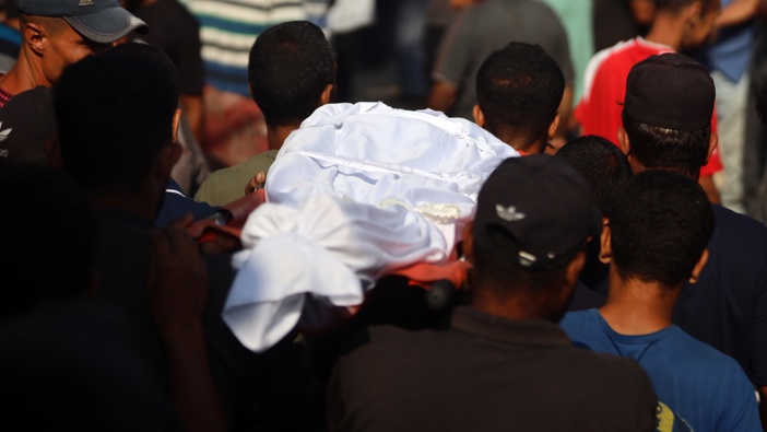 Palestinian men carry the body of a person reportedly killed during overnight Israeli strikes on the grounds of Al-Shifa hospital in the central Gaza Strip on July 7, 2025. (Photo by Majdi Fathi/NurPhoto via Getty Images)
