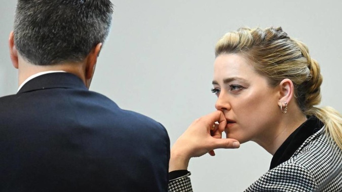 Actor Amber Heard speaks with a legal team member. Photo / AP