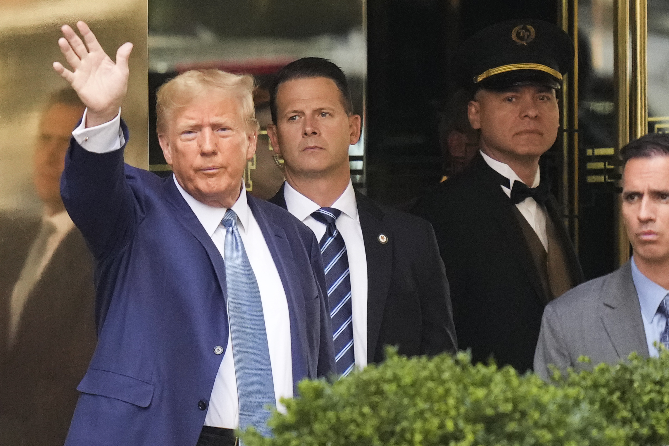 Former President Donald Trump, left, gestures as he leaves Trump Tower in New York, Thursday, April 13, 2023. Trump is expected to visit the offices of New York’s attorney general for his second deposition in a legal battle over his company’s business practices. Photo / AP