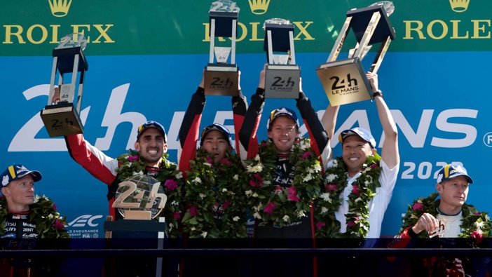 Sebastien Buemi of Switzerland, left, Brendon Hartley, center right, and Ryo Hirakawa of Japan, center left, hold their trophies after winning the 24-Hour Le Mans endurance race. Photo / AP