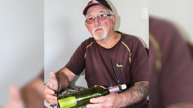 Ken Ferguson with the bottle, complete with a Greek master mariner's card, he found on Ninety Mile Beach. (Photo / Peter Jackson)