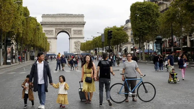 People walk on the champs Elysees avenue during the "day without cars", with the Arc de Triomphe in the background, in Paris, in 2019. Photo / AP